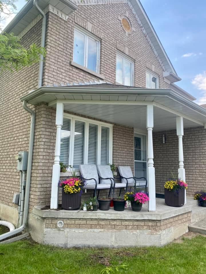 Eavestrough and downspout on a brick two-storey home.
