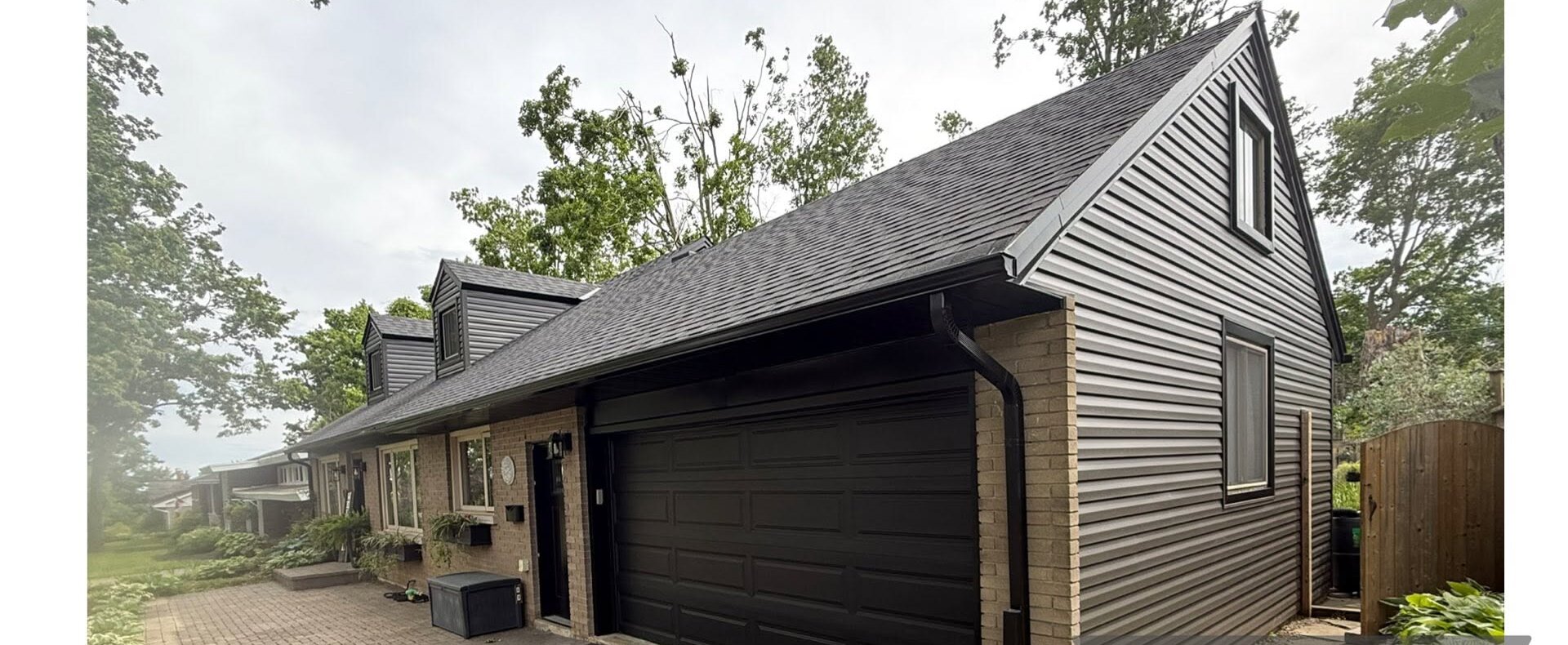 Finished garage exterior with dark board-and-batten siding and black overhead door.